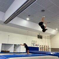 Des enfants sautent sur un trampoline lors d'un entraînement à Shlomi, le 31 juillet 2025. (Crédit : Diana Bletter/Times of Israel)
