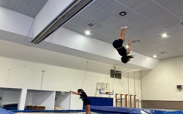 Des enfants sautent sur un trampoline lors d'un entraînement à Shlomi, le 31 juillet 2025. (Crédit : Diana Bletter/Times of Israel)