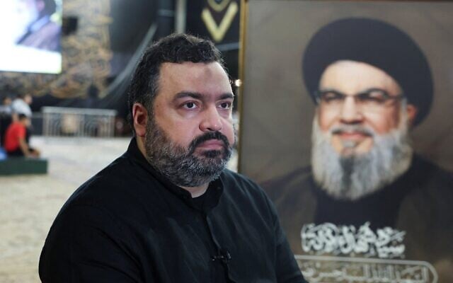 Jawad Nasrallah, fils du chef du Hezbollah Hassan Nasrallah, assis sur le lieu de sépulture à la veille du premier anniversaire de l'assassinat de son père, dans la banlieue de Beyrouth, au Liban, le 24 septembre 2025. (Crédit : Reuters/Mohamed Azakir)