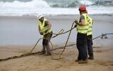 Illustration : Des opérateurs manipulant un câble sous-marin à fibre optique sur la plage d'Arrietara, près du village basque espagnol de Sopelana, le 13 juin 2017. (Crédit : Ander Gillenea/AFP)