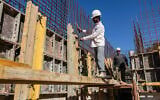 Des maçons indiens travaillant sur un chantier de construction, à Tel Aviv, le 15 décembre 2024. (Crédit : Menahem Kahana/AFP)