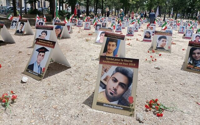 Des portraits d'Iraniens exécutés sont exposés dans un espace des Invalides à Paris, le 8 juillet 2025, dans le cadre d'une campagne menée par des militants français des droits de l'homme pour mettre fin aux exécutions dans la République islamique. (Crédit : Delphine TOUITOU / AFP)