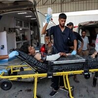 Un Gazaoui, blessé par balle en attendant l'arrivée des camions d'aide humanitaire dans le nord de la bande de Gaza via le passage de Zikim, à son arrivée à l'hôpital al-Shifa, le 27 juillet 2025. (Crédit : Omar al-Qattaa/AFP)