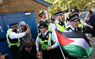 Des manifestants sont retenus par des policiers et des agents de sécurité alors qu'ils protestent devant l'entrée du salon Defence and Security Equipment International (DSEI) au centre ExCeL, dans l'est de Londres, le 9 septembre 2025. (Crédit : Toby Shepheard / AFP)
