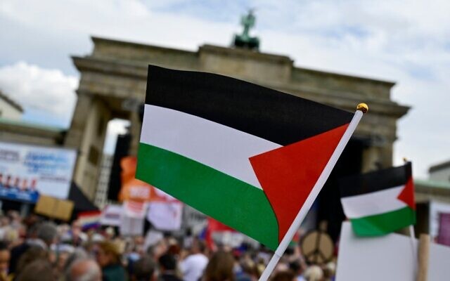 Des manifestants brandissent des drapeaux palestiniens lors d'un rassemblement pour la paix intitulé « Arrêtez le génocide à Gaza ! Pas d'armes dans les zones de guerre ! La paix plutôt que la course aux armements ! » le 13 septembre 2025 à la porte de Brandebourg à Berlin. (Crédit : John MacDougall / AFP) Des manifestants brandissent des drapeaux palestiniens lors d'un rassemblement pour la paix intitulé « Arrêtez le génocide à Gaza ! Pas d'armes dans les zones de guerre ! La paix plutôt que la course aux armements ! » le 13 septembre 2025 à la porte de Brandebourg à Berlin. (Crédit : John MacDougall / AFP)