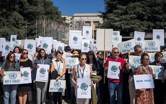 Des employés des agences des Nations Unies brandissent des pancartes devant les bureaux de l'ONU à Genève, le 18 septembre 2025, afin d'honorer la mémoire des 370 employés de l'ONU tués à Gaza et d'appeler à la fin de la guerre entre Israël et le Hamas. (Crédit : Elodie Le Maou/AFP)