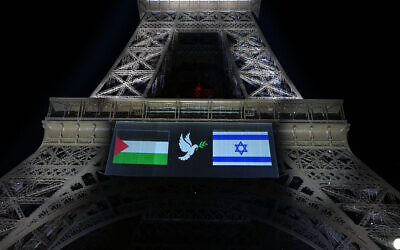 Les images des drapeaux "palestinien" et d'Israël encadrant une colombe avec un rameau d'olivier, projetées sur la tour Eiffel à la veille de la reconnaissance prévue par la France de l'État palestinien, à Paris, le 21 septembre 2025. (Crédit : Bertrand Guay/AFP)