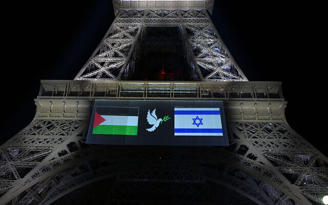 Les images des drapeaux "palestinien" et d'Israël encadrant une colombe avec un rameau d'olivier, projetées sur la tour Eiffel à la veille de la reconnaissance prévue par la France de l'État palestinien, à Paris, le 21 septembre 2025. (Crédit : Bertrand Guay/AFP)