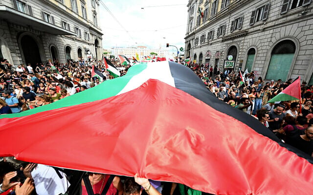 Des manifestants brandissent un drapeau palestinien géant lors de la grève nationale « Bloquez tout », organisée à Rome le 22 septembre en solidarité avec les Palestiniens de Gaza et pour réclamer l'arrêt des livraisons d'armes à Israël. Le syndicat USB a organisé une grève générale nationale de 24 heures, tous secteurs confondus, pour exiger du gouvernement la rupture immédiate de ses relations avec l'État d'Israël, en solidarité avec le peuple palestinien et la Flottille mondiale du Sumud. (Photo : Andreas SOLARO / AFP)