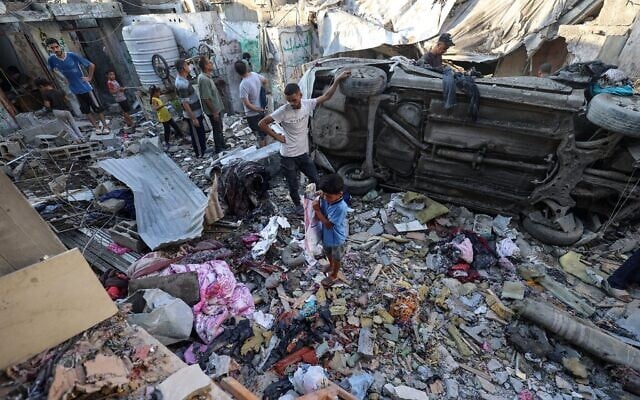 Des Gazaouis inspectant les dégâts à l'extérieur d'une maison frappée par l’armée israélienne, dans le camp de Nuseirat, dans le centre de la bande de Gaza, le 27 septembre 2025. (Crédit : Eyad Baba/AFP)
