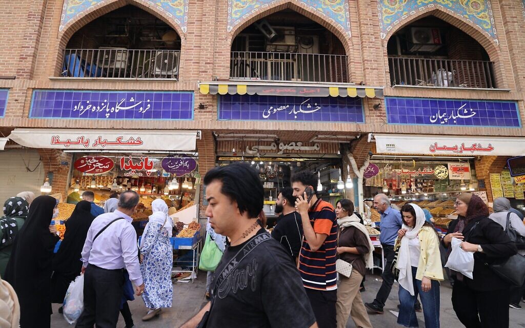 Illustration : des Iraniens passent devant des boutiques du Grand Bazar de Téhéran, le 27 septembre 2025. (Crédit : ATTA KENARE / AFP) Illustration : des Iraniens passent devant des boutiques du Grand Bazar de Téhéran, le 27 septembre 2025. (Crédit : ATTA KENARE / AFP)