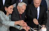 Le président russe Vladimir Poutine, à droite, et Aron Bell, au centre, allument des bougies lors de l’inauguration d’un monument dédié aux héros de la résistance dans les camps de concentration nazis et les ghettos juifs, au Musée juif et Centre de tolérance de Moscou, le 4 juin 2019. (Crédit : Alexei  Druzhinin/Sputnik/Kremlin/AP)