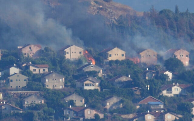 Illustration : Des incendies et de la fumée s'élèvent des maisons de Metula touchées par des tirs de roquettes du Hezbollah, comme on le voit depuis Marjayoun, au Liban, le 22 juin 2024. (Crédit : AP Photo/Hussein Malla)