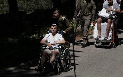 Des soldats israéliens blessés arrivent aux obsèques d'un de leurs camarades au cimetière militaire du mont Herzl à Jérusalem, le 8 juillet 2025. (Crédit : AP Photo/Maya Alleruzzo)