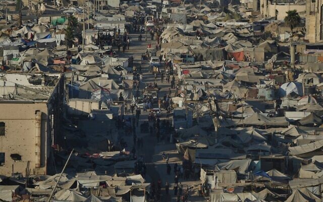 Des Palestiniens traversent un campement de fortune pour personnes déplacées près du port de Gaza-City, lundi 1er septembre 2025. (Crédit : Jehad Alshrafi/AP) Des Palestiniens traversent un campement de fortune pour personnes déplacées près du port de Gaza-City, lundi 1er septembre 2025. (Crédit : Jehad Alshrafi/AP)