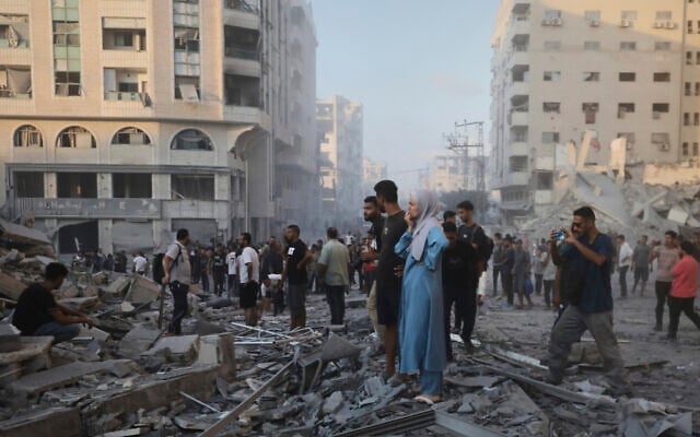 Des Gazaouis inspectant les dégâts causés par une frappe de l'armée israélienne sur un immeuble de Gaza-City, le 7 septembre 2025. (Crédit : Yousef Al Zanoun/AP Photo) Des Gazaouis inspectant les dégâts causés par une frappe de l'armée israélienne sur un immeuble de Gaza-City, le 7 septembre 2025. (Crédit : Yousef Al Zanoun/AP Photo)