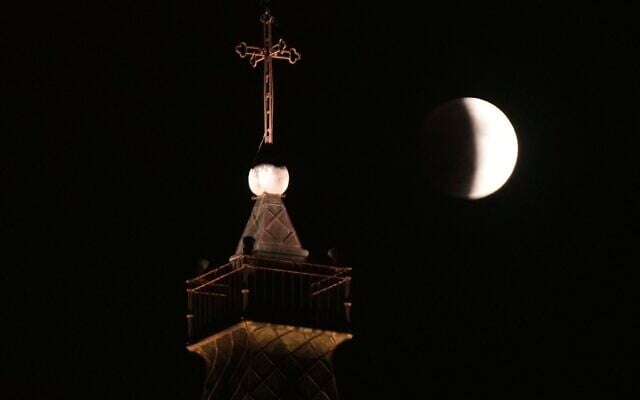 Une éclipse lunaire partielle visible au-dessus d'une église, à Jérusalem, le 7 septembre 2025. (Crédit : Mahmoud Illean/AP) Une éclipse lunaire partielle visible au-dessus d'une église, à Jérusalem, le 7 septembre 2025. (Crédit : Mahmoud Illean/AP)