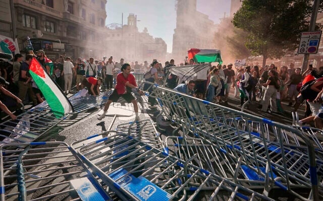Des manifestants bloquant la route afin de perturber la 21ᵉ étape de la course cycliste espagnole La Vuelta, à Madrid, le 14 septembre 2025. (Crédit : Manu Fernández/AP) Des manifestants bloquant la route afin de perturber la 21ᵉ étape de la course cycliste espagnole La Vuelta, à Madrid, le 14 septembre 2025. (Crédit : Manu Fernández/AP)