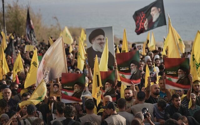 Des partisans du Hezbollah se rassemblent près du rocher emblématique de Raouche, illuminé par un portrait du défunt chef du Hezbollah, Sayyed Hassan Nasrallah, lors d'un événement commémorant sa mort dans des frappes aériennes israéliennes il y a près d'un an, à Beyrouth, au Liban, le 25 septembre 2025. (Crédit : AP/Hussein Malla) Des partisans du Hezbollah se rassemblent près du rocher emblématique de Raouche, illuminé par un portrait du défunt chef du Hezbollah, Sayyed Hassan Nasrallah, lors d'un événement commémorant sa mort dans des frappes aériennes israéliennes il y a près d'un an, à Beyrouth, au Liban, le 25 septembre 2025. (Crédit : AP/Hussein Malla)