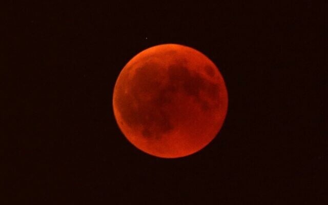Une lune rouge se levant au-dessus de Marseille, dans le sud de la France, le 27 juillet 2018. (Crédit : Claude Paris/AP)