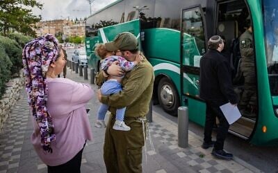 Un soldat israélien de réserve embrasse son enfant pour lui dire au revoir à Jérusalem, le 5 mai 2025 (Crédit : Chaim Goldberg/Flash90)