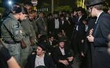 Des hommes haredim participent à un rassemblement contre l'emprisonnement d'étudiants juifs d'un séminaire qui n'ont pas respecté un ordre de recrutement de l'armée, devant la prison militaire de Beit Lid, près de Netanya, le 14 août 2025. (Crédit : Tal Gal/Flash90)