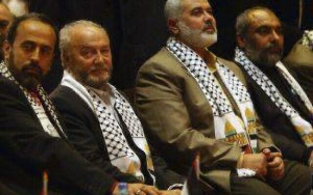 Zaher Birawi, chef de la section britannique du Hamas au sein de la PCPA, aux côtés d'Ismaïl Haniyeh, chef de la branche politique du groupe terroriste palestinien, et le politicien britannique George Galloway, sur une photo diffusée le 30 septembre 2025. (Crédit : Ministère des Affaires étrangères)