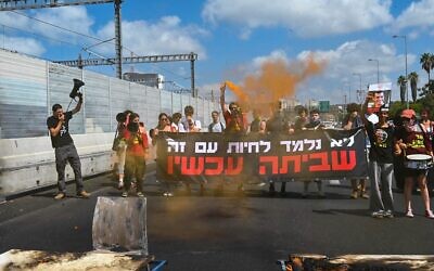 Des adolescents réclamant un accord de cessez-le-feu et de libération des otages incendiant des pupitres et bloquant l'autoroute Ayalon, à Tel Aviv, le 31 août 2025. (Alon Banki/Mouvement de protestation israélien pour la démocratie)