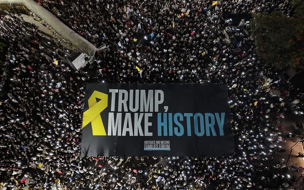 Des manifestants brandissent une grande banderole appelant le président américain Donald Trump à « entrer dans l'histoire » en mettant fin à la guerre à Gaza et en ramenant les otages chez eux, lors d'une manifestation à Tel Aviv le 30 août 2025. (Crédit : Yair Palti/Forum des familles des otages et des disparus)