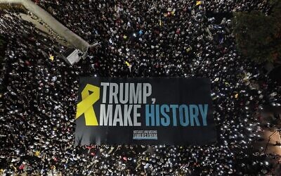 Des manifestants brandissent une grande banderole appelant le président américain Donald Trump à « entrer dans l'histoire » en mettant fin à la guerre à Gaza et en ramenant les otages chez eux, lors d'une manifestation à Tel Aviv le 30 août 2025. (Crédit : Yair Palti/Forum des familles des otages et des disparus)