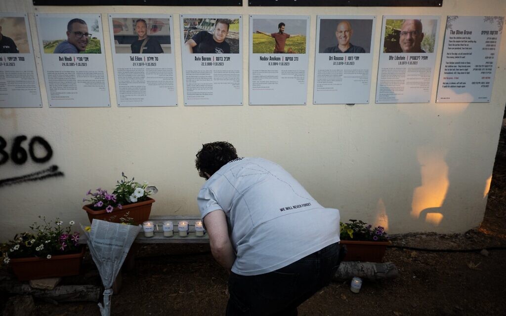 Une femme allume des bougies pour les membres de l'équipe de sécurité de Kfar Aza, le 7 octobre 2025. (Crédit : Luke Tress/Times of Israel)