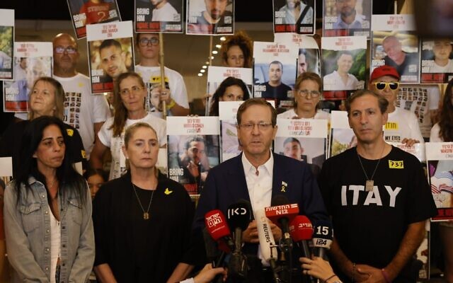 Isaac Herzog (2ᵉ à droite) accompagné de familles d'otages s'adressant à la foule, à Tel Aviv, le 12 octobre 2025. (Crédit : Yossi Zamir/GPO)