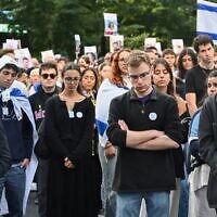 Des partisans d'Israël observent une minute de silence lors d'une veillée devant l'Université McGill à Montréal, au Canada, le 7 octobre 2024, en hommage aux victimes du massacre du 7 octobre perpétré par le Hamas en Israël. (Graham Hughes / AFP)