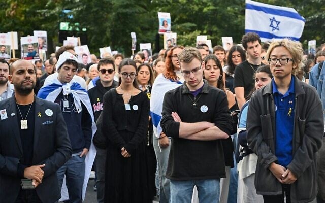 Des partisans d'Israël observent une minute de silence lors d'une veillée devant l'Université McGill à Montréal, au Canada, le 7 octobre 2024, en hommage aux victimes du massacre du 7 octobre perpétré par le Hamas en Israël. (Graham Hughes / AFP)