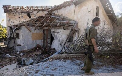 Illustration : Un soldat israélien se tient devant une maison touchée par des roquettes du Hezbollah dans la ville déserte de Metula, dans le nord d'Israël, le 4 novembre 2024. (Crédit : Menahem KAHANA / AFP)