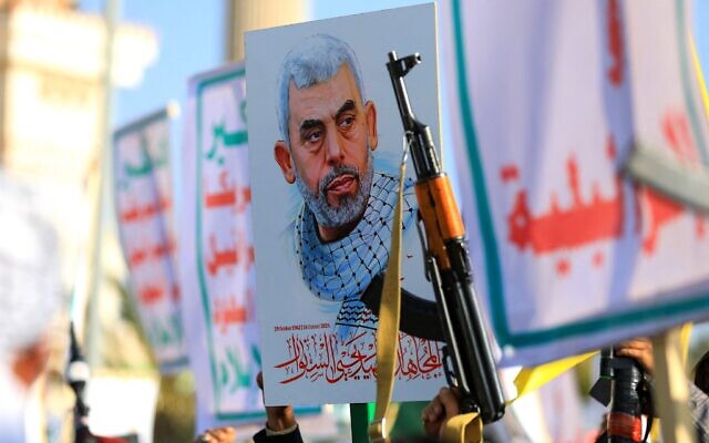 Des Yéménites brandissent des fusils et tiennent une photo du chef terroriste du Hamas Yahya Sinwar, tué lors d'un rassemblement de solidarité avec Gaza dans la capitale Sanaa, contrôlée par les Houthis, le 29 novembre 2024. (Crédit : Mohammed HUWAIS / AFP)