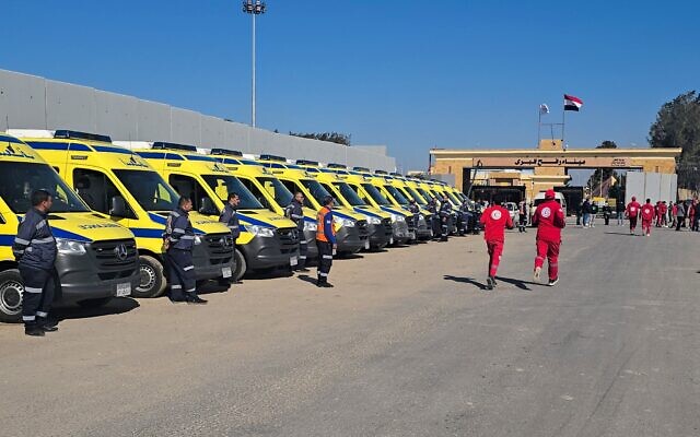 Des ambulanciers et des ambulances attendent du côté égyptien du poste-frontière de Rafah avec la bande de Gaza, le 18 janvier 2025. (Crédit : AFP)