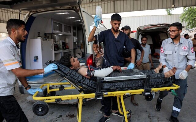 Un petit garçon palestinien, blessé par balle, est descendu d'une ambulance après son arrivée à l'hôpital Shifa de Gaza pour y recevoir des soins médicaux, le 27 juillet 2025. (Crédit : Omar Al-Qattaa/AFP)