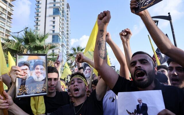 Des partisans du Hezbollah brandissant les drapeaux jaunes du groupe terroriste chiite libanais et des photos de son défunt chef, Hassan Nasrallah, à l'occasion du premier anniversaire de sa mort, dans le quartier côtier de Raouche, à Beyrouth, le 25 septembre 2025. (Crédit : Anwar Amro/AFP)