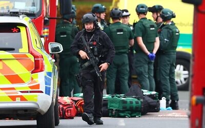 Illustration : Des policiers armés se tenant avec leurs armes à l'intérieur d'un cordon de police établi après une attaque terroriste meurtrière perpétrée dans la synagogue Heaton Park Hebrew Congregation, à Crumpsall, au nord de Manchester, le 2 octobre 2025. (Crédit : Paul Currie/AFP)