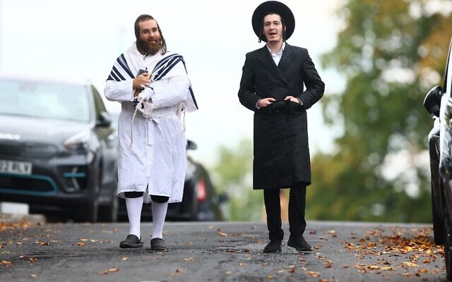 Des membres de la communauté juive locale marchent dans la rue près de la synagogue Heaton Park Hebrew Congregation à Crumpsall, au nord de Manchester, le 2 octobre 2025. (Crédit : Paul Currie / AFP)