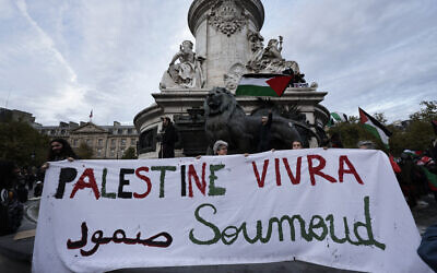 Les participants brandissent une banderole sur laquelle on peut lire « Palestine vivra » lors d'une manifestation de solidarité avec les Palestiniens et pour condamner l'interception de la flottille Global Sumud par l'armée israélienne, place de la République à Paris, le 2 octobre 2025. (Crédit  : STEPHANE DE SAKUTIN / AFP)