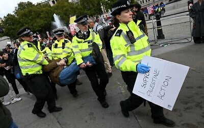 Un manifestant est emmené par des policiers lors d'une manifestation « Lift The Ban » (Levez l'interdiction) en soutien au groupe interdit Palestine Action, qui réclame la levée de l'interdiction récemment imposée, à Trafalgar Square, dans le centre de Londres, le 4 octobre 2025. (Crédit : JUSTIN TALLIS / AFP)