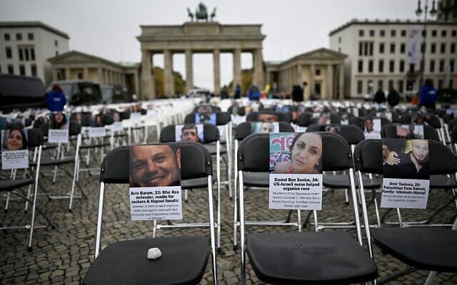 Plus de 1 000 chaises ornées de photos d'otages israéliens et de personnes assassinées le 7 octobre 2023 ont été installées en mémoire des victimes du massacre perpétré par le Hamas, dans le cadre d'une installation organisée par l'Union des étudiants juifs d'Allemagne, devant la porte de Brandebourg, à Berlin, le 7 octobre 2025. (Crédit : Tobias Schwarz / AFP)