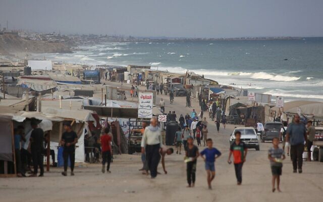 Des Gazaouis déplacés commençant leur journée dans un camp de fortune près de la plage de la ville d'al-Zawayda, près de Deir al-Balah, dans le centre de la bande de Gaza, le 9 octobre 2025, après l'annonce dans la nuit d'un accord de cessez-le-feu entre le Hamas et Israël qui doit être signé en Égypte. (Crédit : Bashar Taleb/AFP)