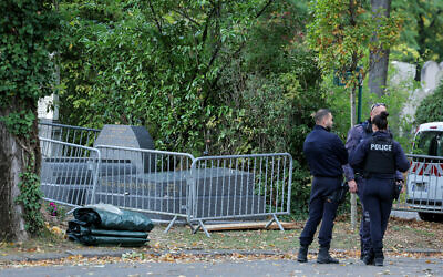 Des policiers français se tenant près de la tombe de l'ancien ministre français de la Justice Robert Badinter, qui a été vandalisée quelques heures avant son transfert au Panthéon, au cimetière de Bagneux, près de Paris, le 9 octobre 2025. Selon une source policière, des mots ont été tagués en bleu sur la pierre tombale de l'ancien avocat, décédé en février 2024. Le vandalisme de la tombe de l'architecte de l'abolition de la peine de mort en France s'est produit quelques heures avant son entrée au Panthéon le soir du 9 octobre 2025, lors d'une cérémonie solennelle présidée par le président de la République. (Crédit : Thomas Samson/AFP)