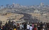 Des Palestiniens marchent depuis Nuseirat, dans le centre de la bande de Gaza, sur la route Al-Rashid en direction de Gaza-City, le 10 octobre 2025. (Crédit : Bashar TALEB / AFP)