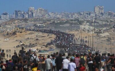 Des Palestiniens marchent depuis Nuseirat, dans le centre de la bande de Gaza, sur la route Al-Rashid en direction de Gaza-City, le 10 octobre 2025. (Crédit : Bashar TALEB / AFP)