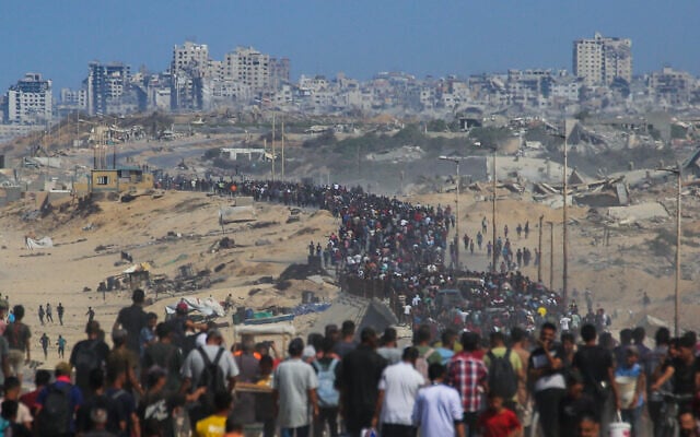 Des Palestiniens marchent depuis Nuseirat, dans le centre de la bande de Gaza, sur la route Al-Rashid en direction de Gaza-City, le 10 octobre 2025. (Crédit : Bashar TALEB / AFP) Des Palestiniens marchent depuis Nuseirat, dans le centre de la bande de Gaza, sur la route Al-Rashid en direction de Gaza-City, le 10 octobre 2025. (Crédit : Bashar TALEB / AFP)