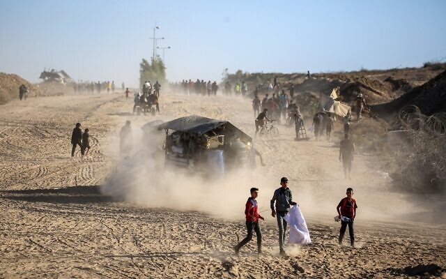Des Gazauis se rendant à Gaza-City en empruntant le corridor Netzarim, dans le centre de la bande de Gaza, le 11 octobre 2025. (Crédit : Eyad Baba/AFP)